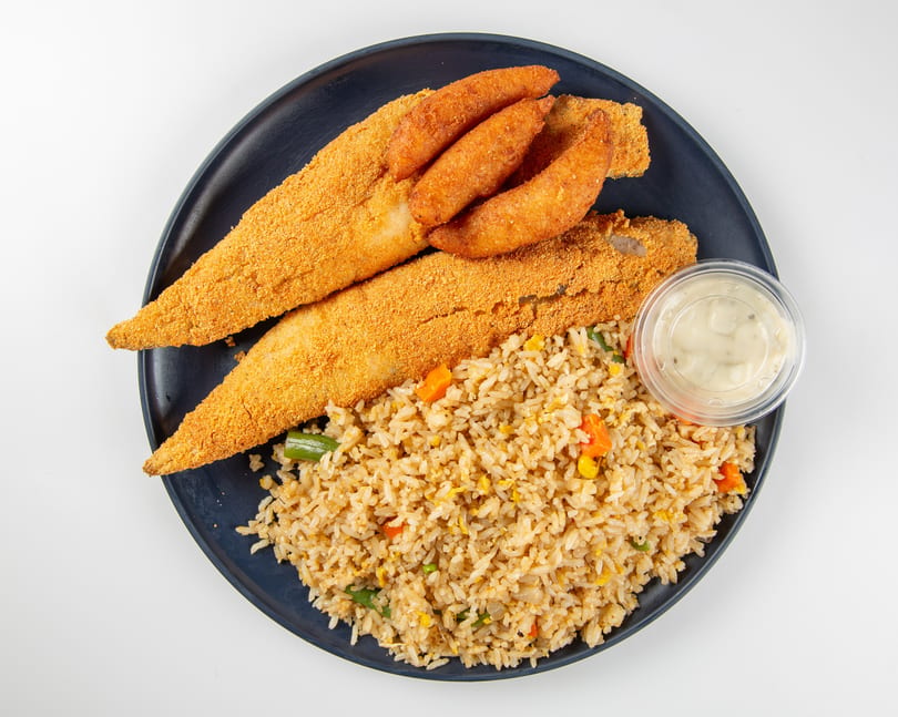 Fried fish fillets and hush puppies with vegetable fried rice and tartar sauce on a dark plate.